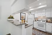 Thumbnail 43 of 100 - a kitchen with white cabinetry and white appliances