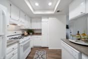 Thumbnail 41 of 100 - a kitchen with white cabinetry and a white stove top oven