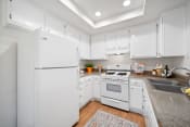 Thumbnail 26 of 100 - a kitchen with white cabinetry and white appliances