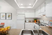 Thumbnail 23 of 100 - a kitchen with white cabinets and white appliances