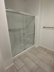 Thumbnail 9 of 11 - a shower in a bathroom with a sliding glass door