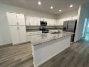 Thumbnail 5 of 11 - a kitchen with white cabinets and a granite counter top