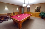 Thumbnail 20 of 27 - a red pool table in a room with a wooden table and chairs