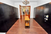 Thumbnail 53 of 61 - a long hallway with dark brown lockers and a small table