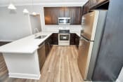 Thumbnail 56 of 61 - a kitchen with dark wood cabinets and white countertops