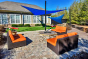 Thumbnail 55 of 61 - a patio with a fire pit and lounge chairs in front of a house