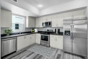 Thumbnail 3 of 18 - a kitchen with stainless steel appliances and white cabinets
