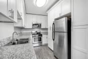 Thumbnail 8 of 42 - a kitchen with white cabinets and stainless steel appliances