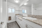 Thumbnail 18 of 42 - a bathroom with white cabinets and granite counter tops
