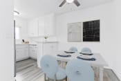 Thumbnail 3 of 23 - a white kitchen with a white table and blue chairs