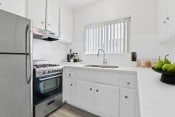 Thumbnail 1 of 23 - a white kitchen with stainless steel appliances and white cabinets