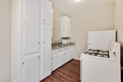 Thumbnail 17 of 17 - Kitchen With White Appliances, Refrigerator, Gas Range, Microwave, Stainless double kitchen sink with granite countertops, White kitchen cabinets, wood-style flooring