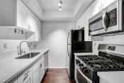 Thumbnail 2 of 33 - a kitchen with white cabinets and stainless steel appliances