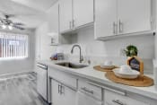 Thumbnail 2 of 44 - a white kitchen with white cabinets and a stainless steel sink