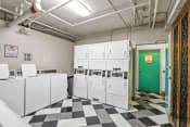 Thumbnail 14 of 21 - a laundry room with white machines and a green door