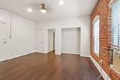 Thumbnail 5 of 21 - a living room with hardwood floors and a brick wall