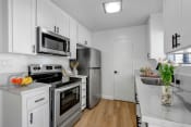 Thumbnail 2 of 19 - a kitchen with white cabinetry and stainless steel appliances
