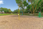 Thumbnail 7 of 21 - Playground at Ashley Pointe Apartments with swing sets, tetherball and climbing equipment