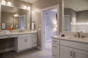 Thumbnail 38 of 41 - Master bathroom with two vanities, a neutral colored wall, and white cabinets in the penthouse