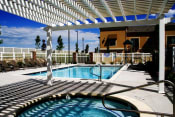 Thumbnail 7 of 15 - Liberty Landing Apartments swimming pool and spa with a white pergola over it