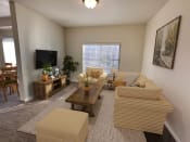 Thumbnail 13 of 15 - Liberty Landing Apartments in West Jordan Utah living room in Midway floor plan with couch, coffee table and television.