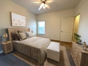 Thumbnail 12 of 15 - Liberty Landing Apartments in West Jordan Utah bedroom with a full-sized bed and ceiling fan.