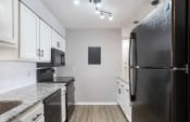 Thumbnail 24 of 70 - a renovated kitchen with white cabinets, quartz countertops, and black appliances