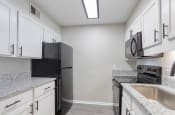 Thumbnail 65 of 70 - a renovated kitchen with black appliances and white cabinets