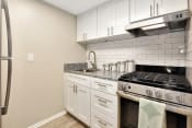 Thumbnail 19 of 32 - An apartment kitchen with stainless steel appliances and granite countertops at The Oasis Apartments in Daytona Beach, FL