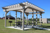 Thumbnail 12 of 18 - Large Pergola on a concrete slab with picnic tables and grilling stations
