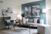 Thumbnail 13 of 30 - living room with hardwood-style flooring and teal accent wall and model furniture  at Huntsville Landing Apartments, Alabama, 35806
