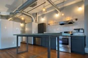Thumbnail 2 of 24 - upgraded kitchen with pendant lighting, stainless steel appliances, and concrete island at Jemison Flats, Birmingham, Alabama
