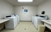 Thumbnail 24 of 24 - a group of washers and dryers in the laundry center at Algonquin Manor