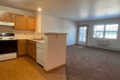 Thumbnail 11 of 24 - a spacious kitchen and living room with appliances, cabinets, and carpeting
