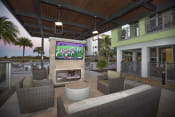 Thumbnail 22 of 44 - Outdoor TV and fireplace lounge poolside at The Residences at The Green in Lakewood Ranch, Florida