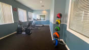 Thumbnail 8 of 28 - Fitness center with a mirror on the back wall, medicine balls, treadmill, elliptical, and stationary bike