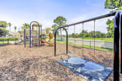 Thumbnail 14 of 23 - Playground equipment with a slide and a separate swing set with two swings.