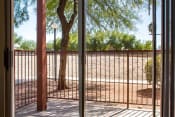 Thumbnail 16 of 16 - Private Patio with Sliding Glass Doors and Metal Railing Next to Tree