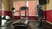 Thumbnail 12 of 15 - Fitness center with treadmill, exercise bike, elliptical, and tv mounted on wall