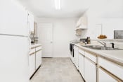 Thumbnail 12 of 25 - Virtually staged kitchen with tile floors and white appliances.