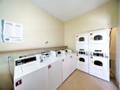 Thumbnail 5 of 24 - Clothing care center with washers, dryers, and folding station