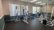 Thumbnail 12 of 31 - Fitness center with wall made of mirrors and weight machines