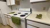 Thumbnail 17 of 31 - Kitchen with tile flooring featuring white cabinets, white appliances, white countertop, and green hand towel and oven mitt