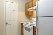 Thumbnail 26 of 49 - a kitchen with white appliances and wooden cabinets