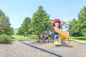 Thumbnail 4 of 25 - Playground on Mulch in Grassy Courtyard with Building Exterior in the Background
