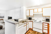 Thumbnail 13 of 25 - Model Kitchen with White Appliances, Grey Counters and White Cabinets with Wood Accents