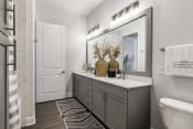 Thumbnail 35 of 39 - a bathroom with gray cabinets and white countertops