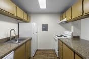 Thumbnail 11 of 19 - a kitchen with a white refrigerator next to a stove top oven at Willows Court Apartment Homes, Seattle, Washington 98125
