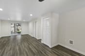 Thumbnail 14 of 18 - Spacious Living Room with Plank Flooring and White Walls and Recessed Lighting at Park 210 Apartment Homes, Edmonds, Washington