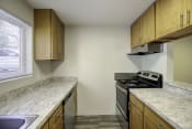 Thumbnail 18 of 18 - a kitchen with wooden cabinets and granite countertops at Park 210 Apartment Homes, Edmonds, Washington